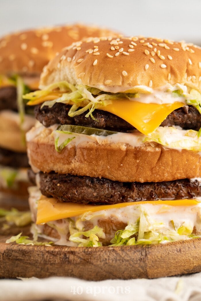 Close-up of a stack of keto big macs on a wooden board.