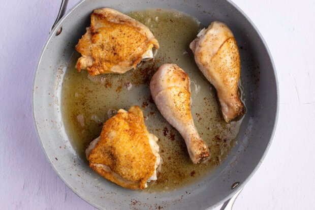 Chicken thighs and drumsticks in large skillet.