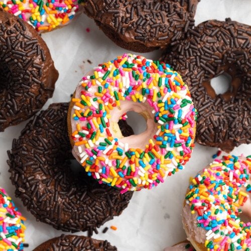 Overhead view of a mix of chocolate and vanilla gluten-free sprinkled donuts.