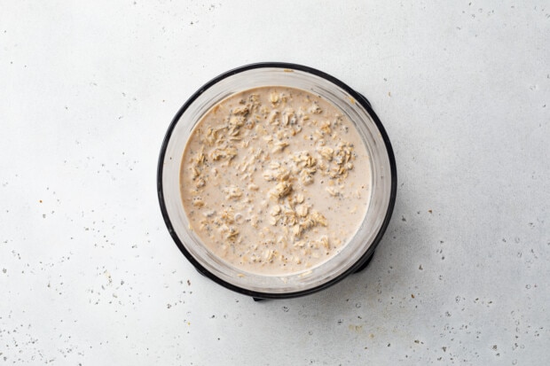 Overhead view of ingredients for overnight oats in a glass bowl.