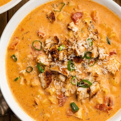 Overhead, close-up view of a bowl of creamy cajun chicken pasta soup.