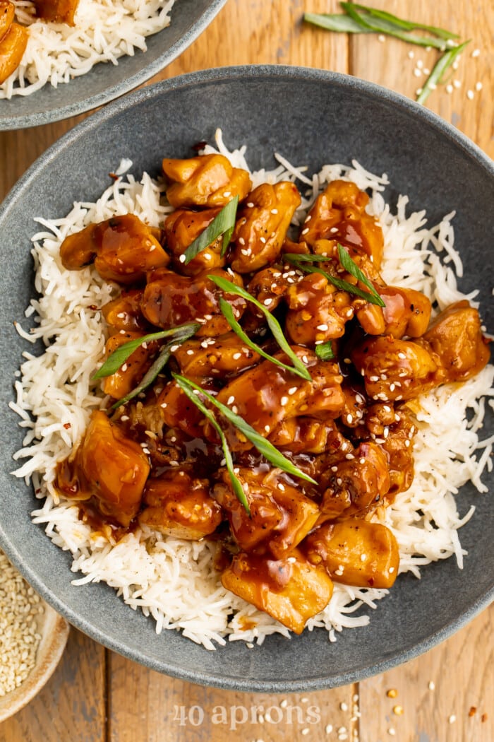 Close-up, overhead view of a bowl of Bourbon chicken on a bed of white rice.