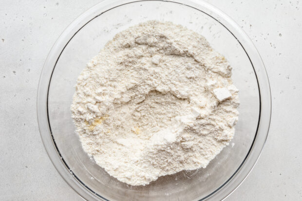 Overhead view of dry ingredients for gluten free lemon drizzle cake in a glass mixing bowl.