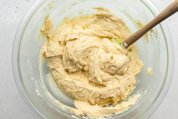 Overhead view of batter for gluten free lemon drizzle cake in a large glass mixing bowl.