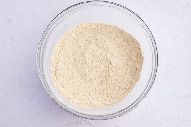 Overhead view of dry ingredients for seitan fried "chicken" tenders in a large glass mixing bowl.