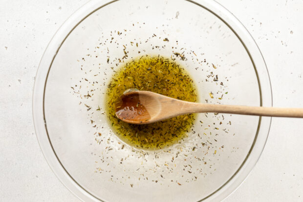 Ingredients for white bean salad dressing in large glass mixing bowl.