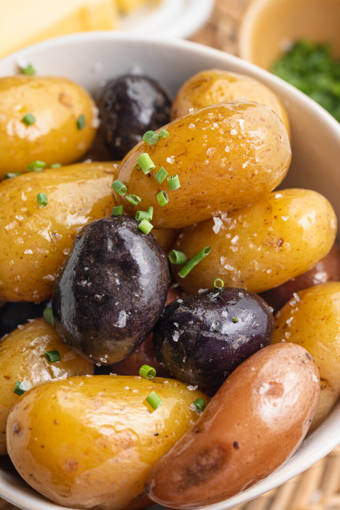 Close-up view of boiled red, yellow, and gold potatoes in a large bowl.