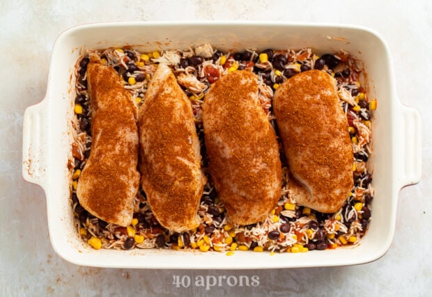 Overhead view of uncooked Mexican chicken casserole in white, rectangular casserole dish.