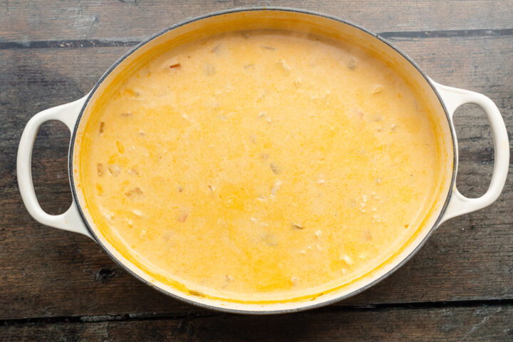 Overhead view of buffalo chicken soup in a large soup pot on a wooden table.