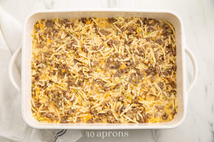 Overhead view of an unbaked gluten free breakfast casserole in a white rectangular casserole dish.