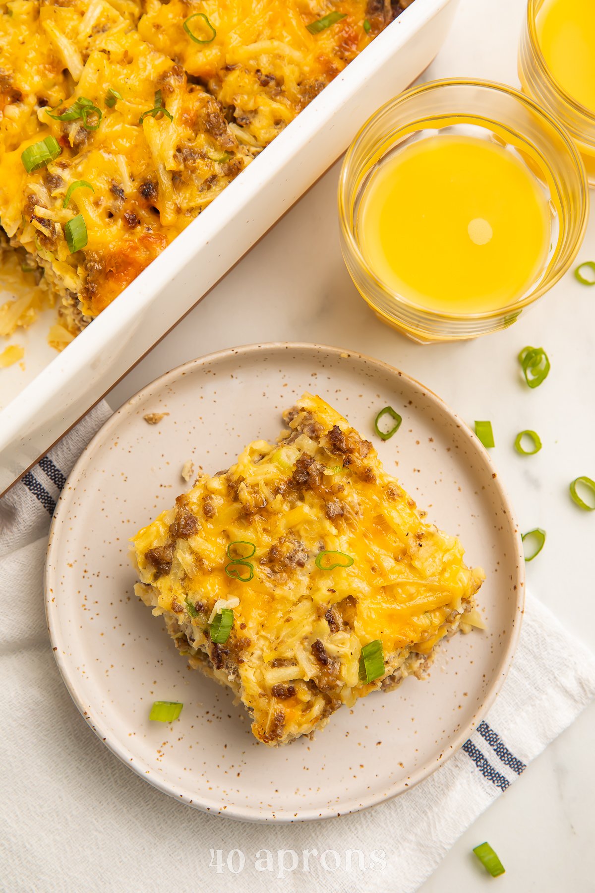 Overhead view of a square of a gluten free breakfast casserole on a plate next to a rectangular casserole dish.