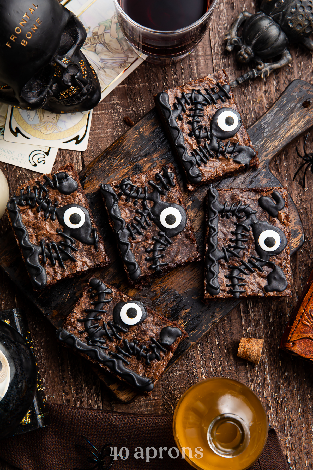 Overhead view of 5 Hocus Pocus spellbook brownies on a wooden tray surrounded by Halloween imagery.