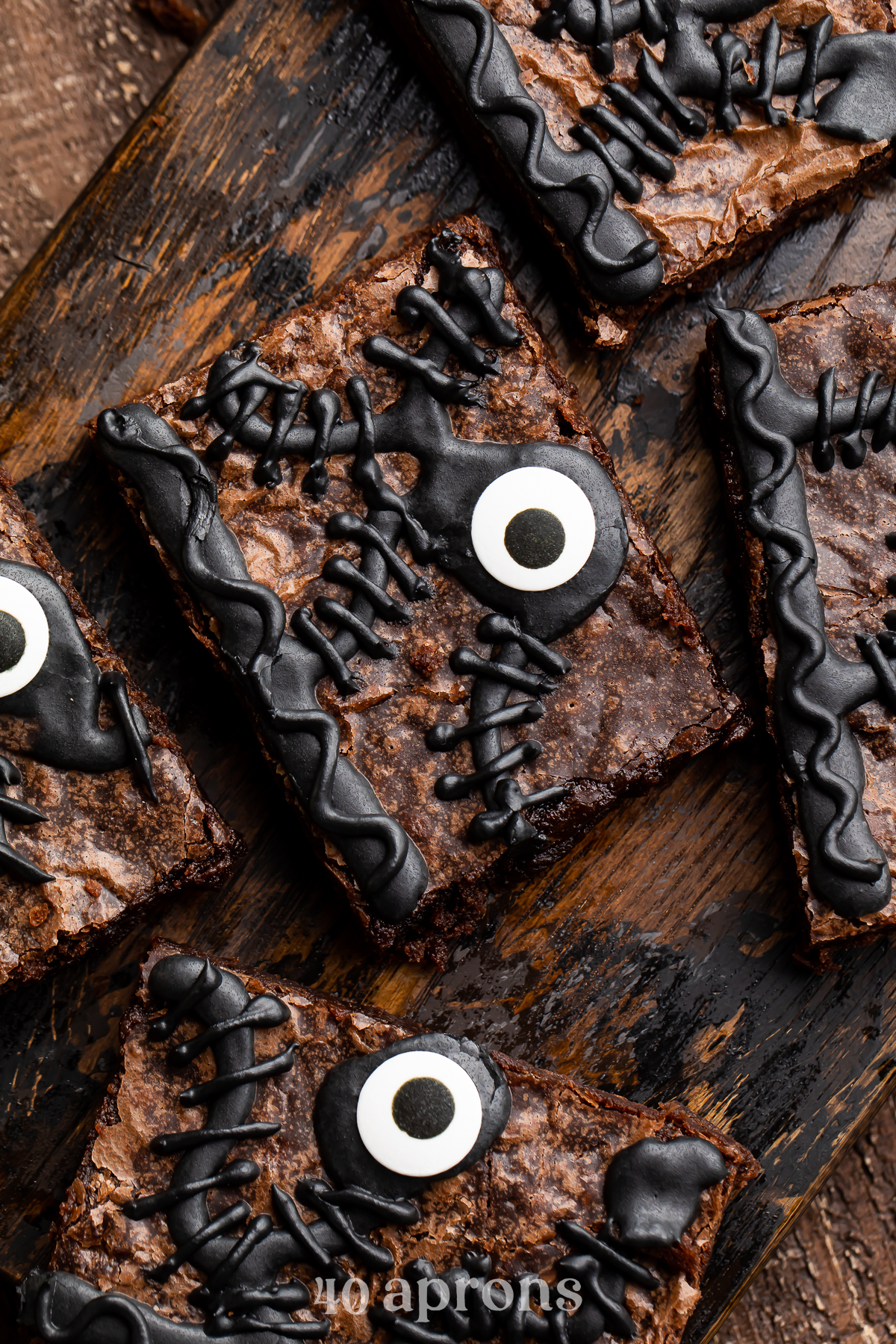 Close-up of one Hocus Pocus spellbook brownie out of 5 on a wooden tray surrounded by Halloween imagery.