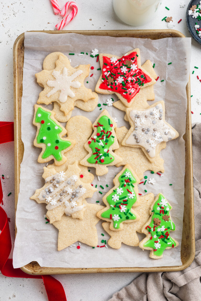 Overhead view of a pan of gluten-free Christmas cookies decorated with icing and sprinkles.