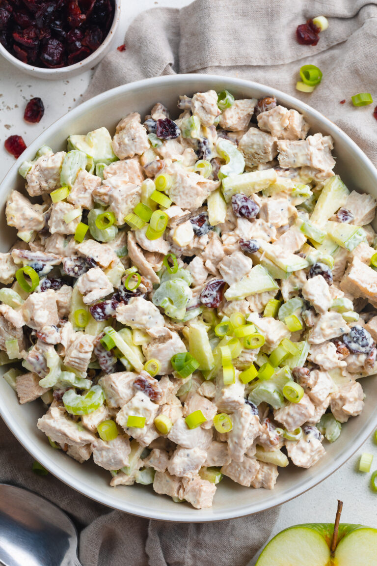 Overhead view of a big bowl of leftover turkey salad with pecans and cranberries.