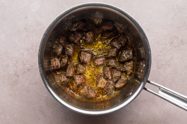 Overhead view of cubed sirloin steak in a large saucepan.z