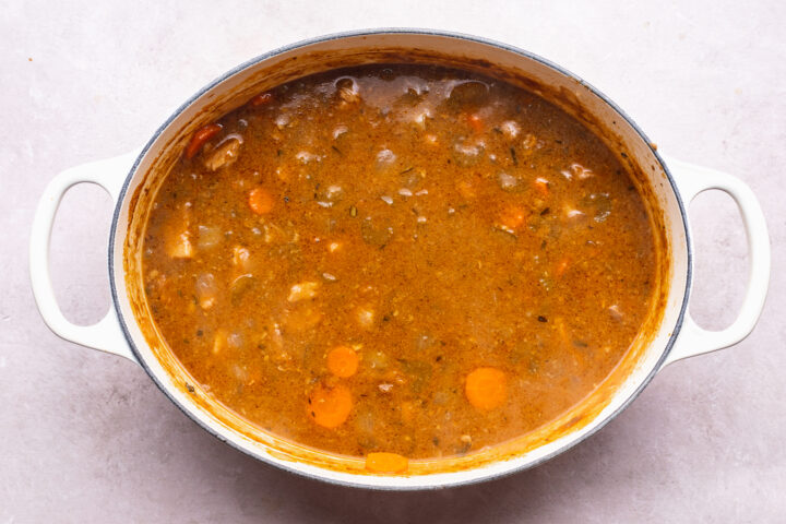 Overhead view of pork stew in a large dutch oven.