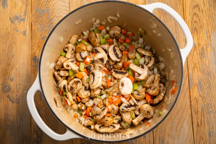 Overhead view of veggies for chicken and wild rice soup in a large heavy soup pot.