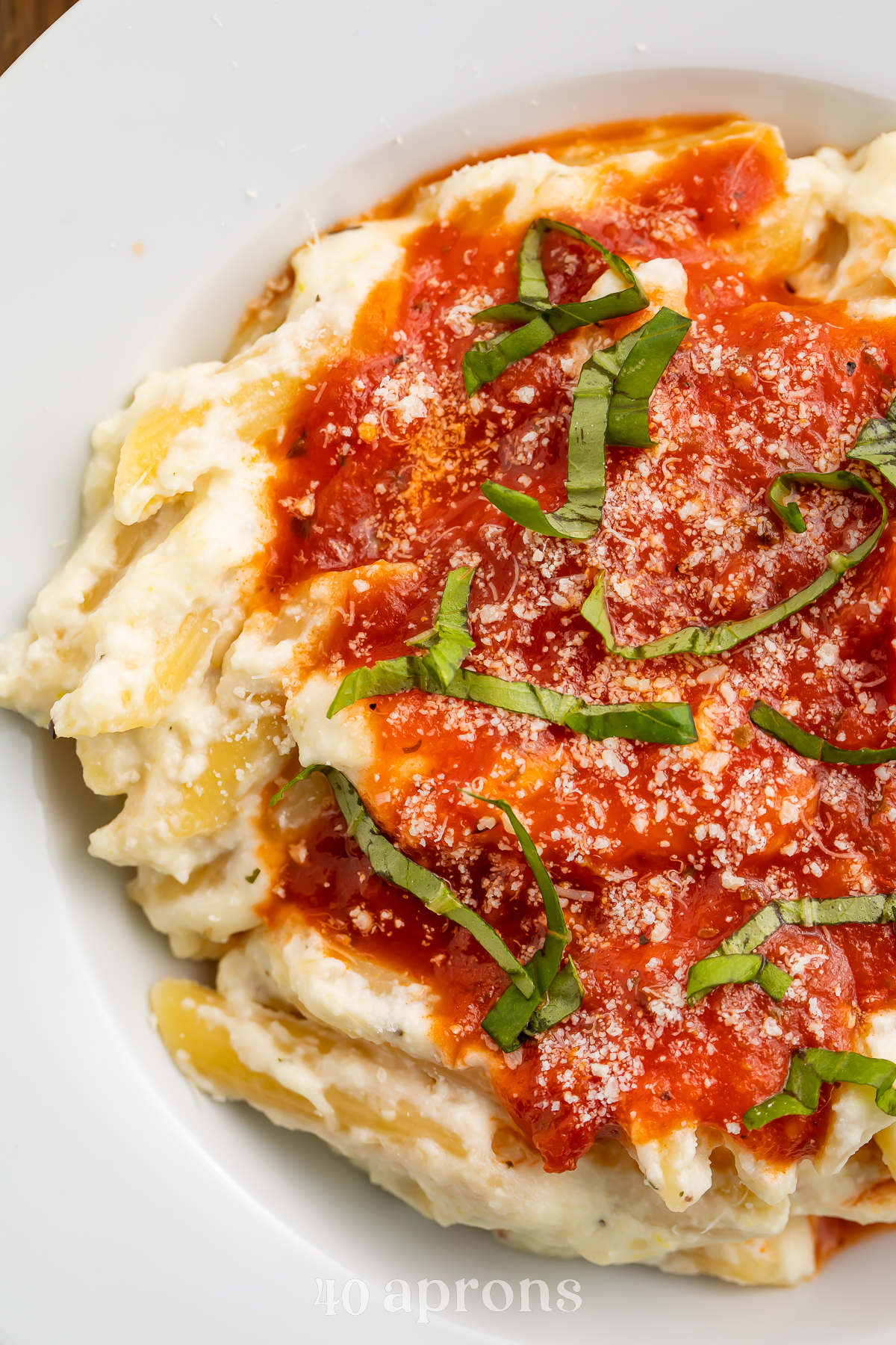 Close-up view of lemon ricotta pasta with marinara and parmesan.