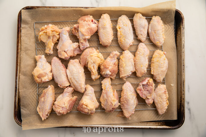 "Breaded" Whole30 chicken wings on a baking sheet lined with parchment paper.