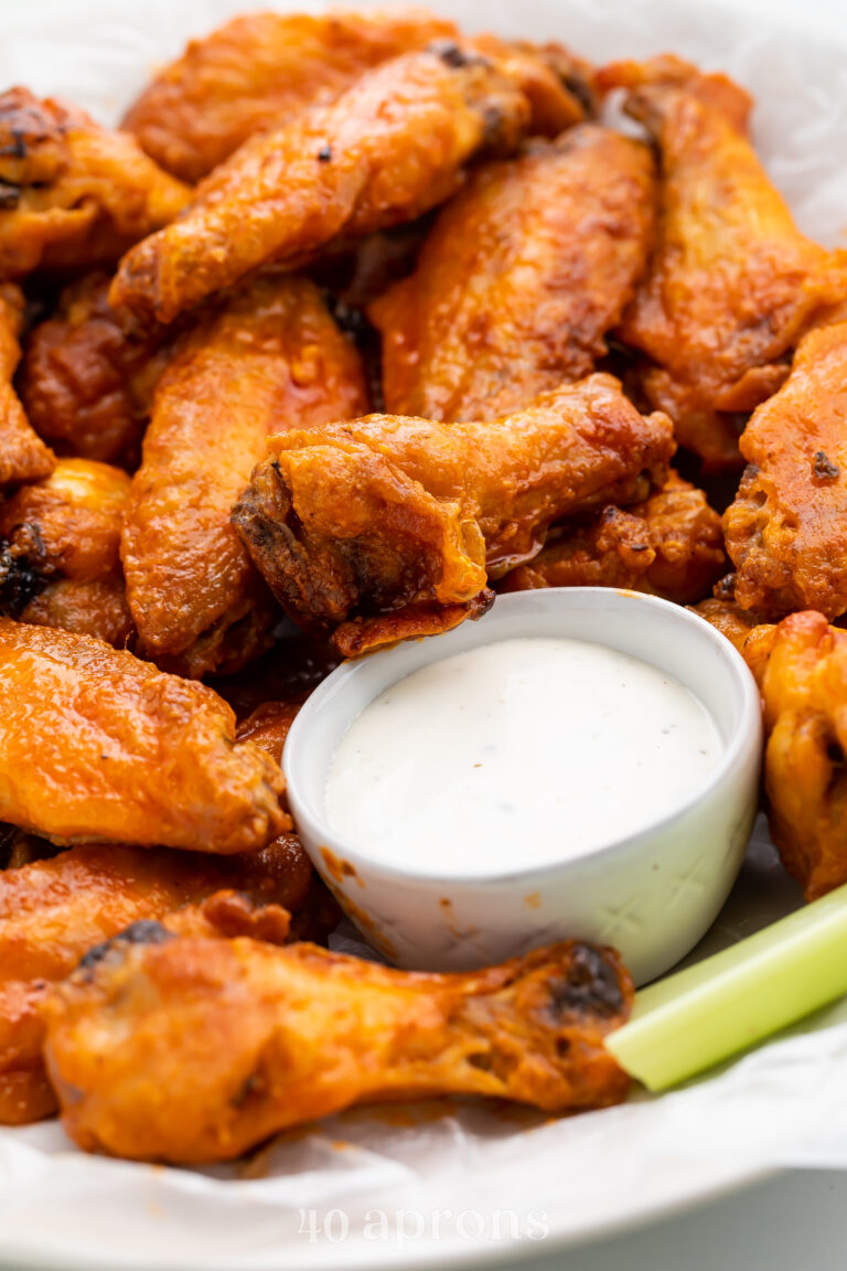 Crispy Whole30 chicken wings coated in buffalo sauce and served next to Whole30 ranch dipping sauce.