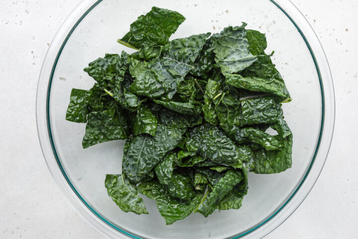 Kale in a bowl with neutral oil and salt.