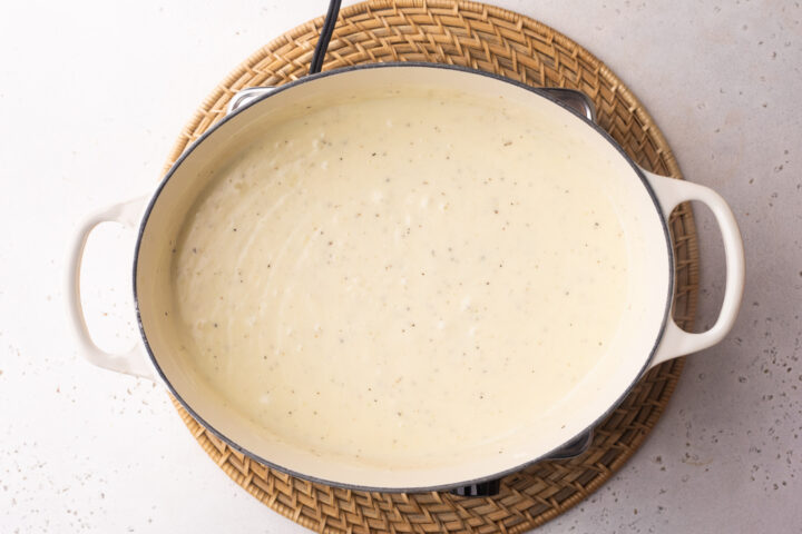 Overhead view of baking dish with lobster cheese sauce in a large oval baking dish with two handles.