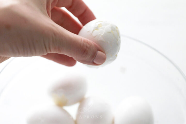 A boiled egg with a very cracked shell ready to peel.