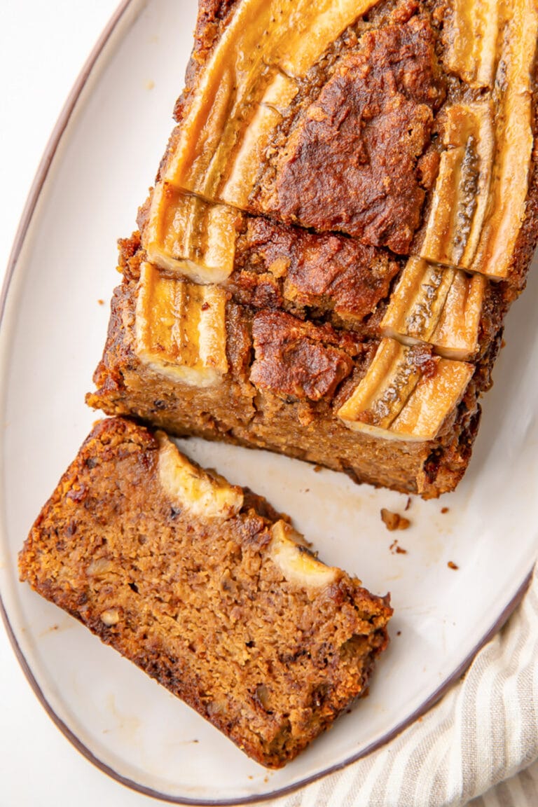 Almond flour banana bread loaf on a platter. The end piece is laying flat on the platter.