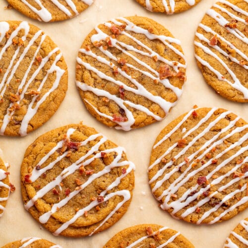 Bacon cookie butter cookies with a cinnamon glaze drizzle arranged on parchment paper.