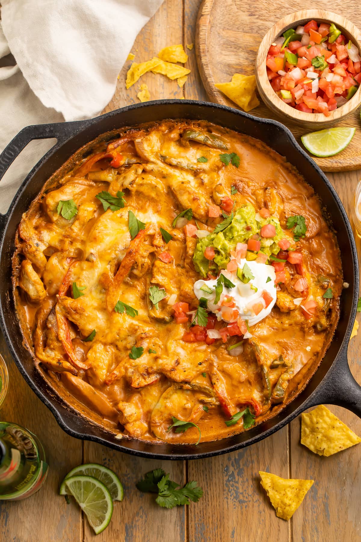 Chicken fajita casserole with a creamy sauce and a dollop of sour cream in a cast-iron skillet.