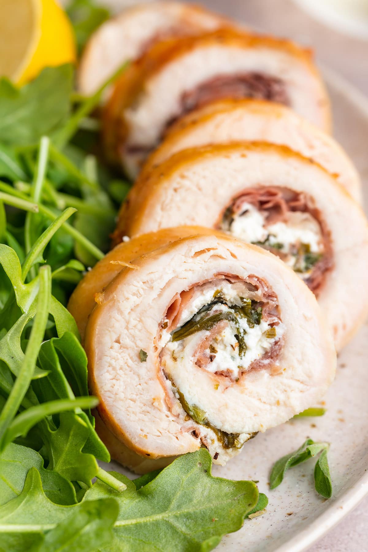 Chicken roulade sliced and plated with a small salad.