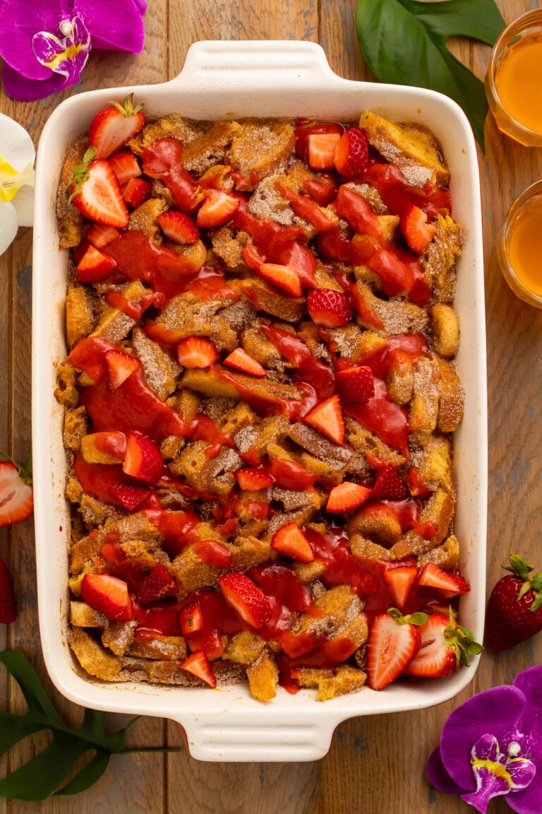 Overhead view of a large casserole dish filled with french toast, bananas, and strawberries.