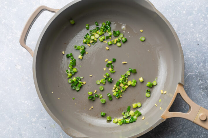 Green onions, grated fresh ginger, and sesame oil in a large skillet.