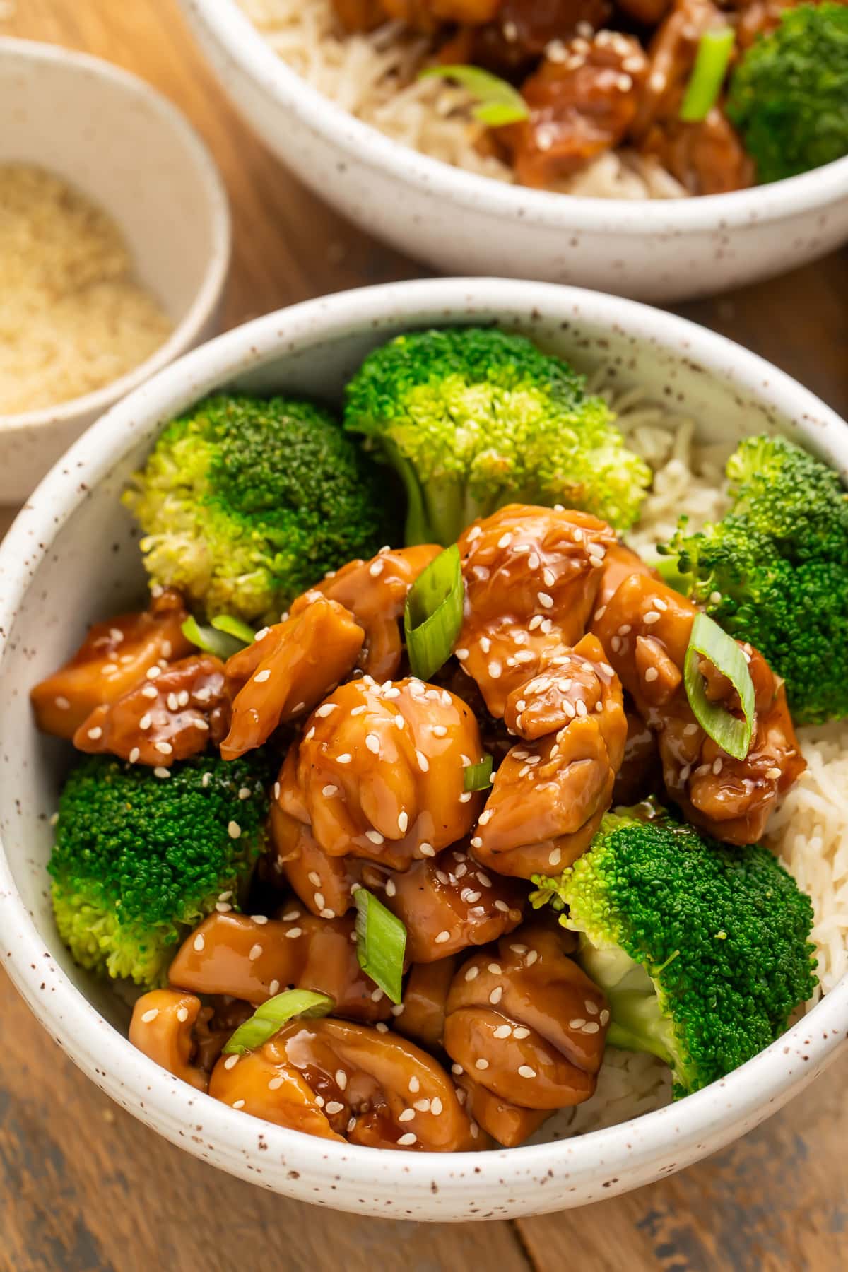 Angled side view of a bowl of Instant Pot chicken teriyaki with steamed broccoli on a bed of white rice.