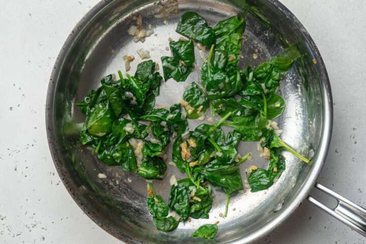 Shallots, garlic, butter, and wilted spinach in a large skillet.