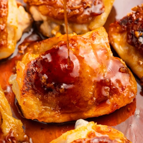 Close-up of a honey garlic chicken thigh in a skillet with honey-garlic sauce.