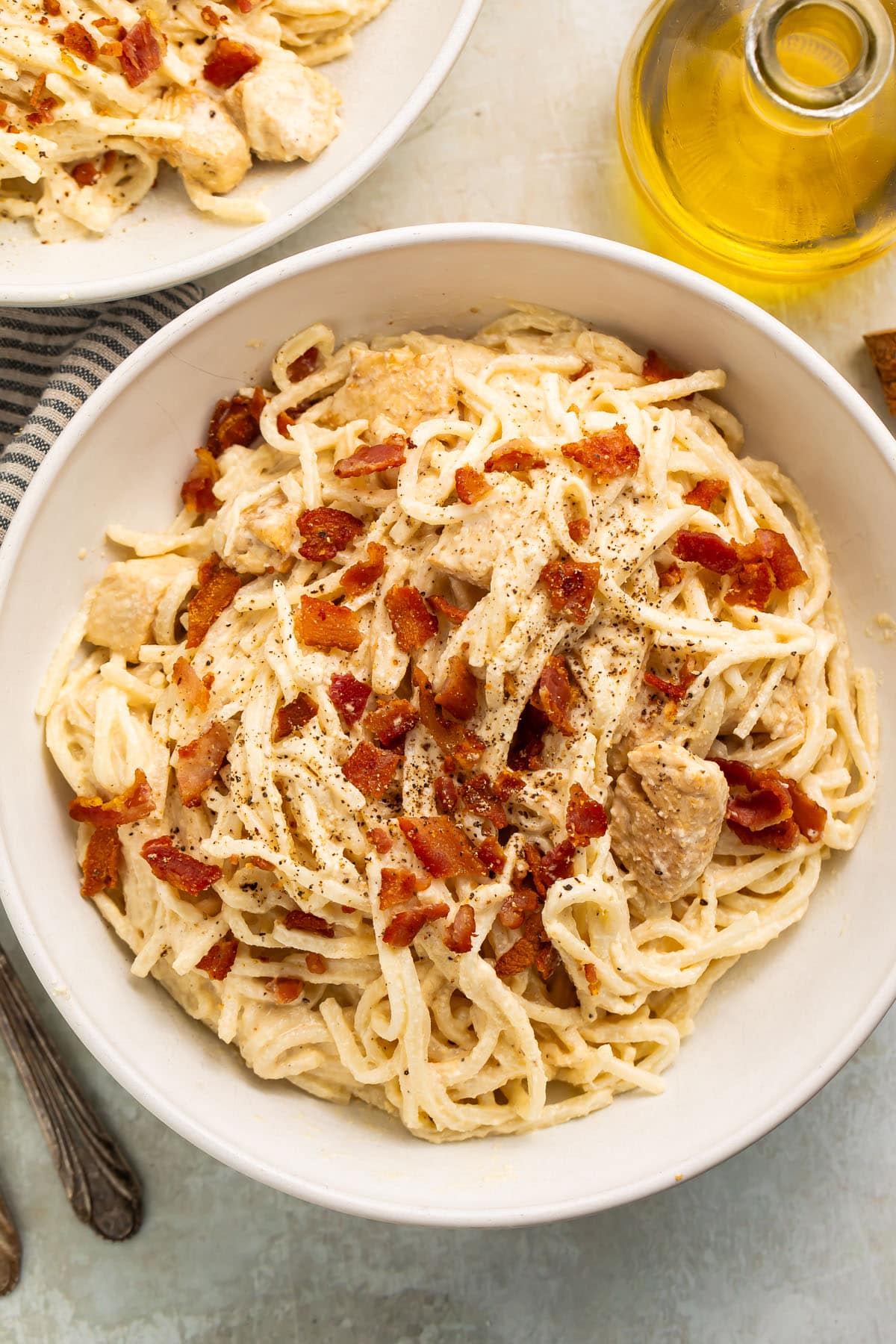 A large white bowl of paleo carbonara made with palmini, dairy-free Alfredo sauce, and compatible bacon.