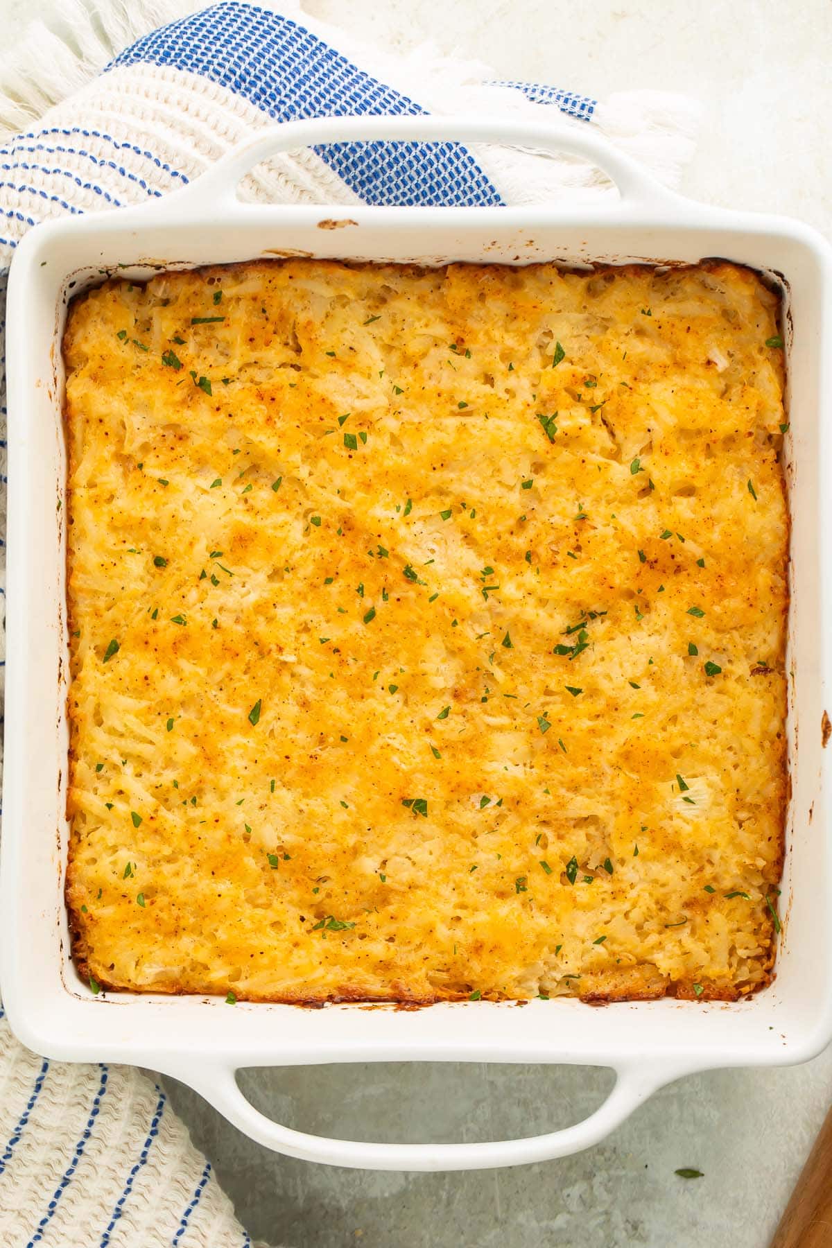 Overhead photo of a full casserole dish of cheesy potato casserole.