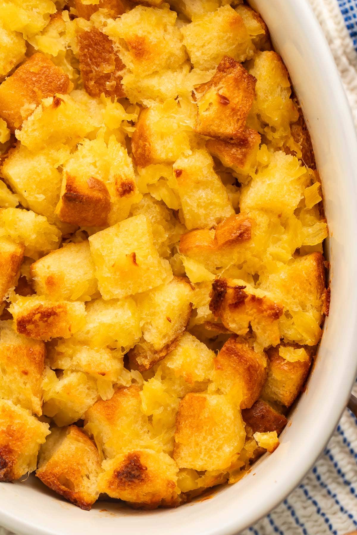 A close-up of pineapple stuffing in a large white oval ceramic baking dish.